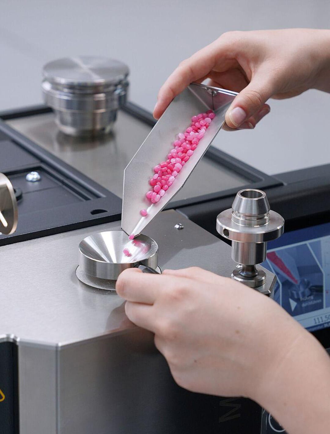 Polymer granules being loaded into the heated barrel of a melt flow indexer prior to testing.